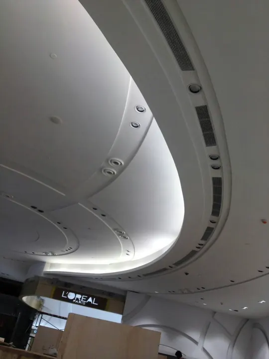 Linear grilles on a curved bulkhead in a retail store