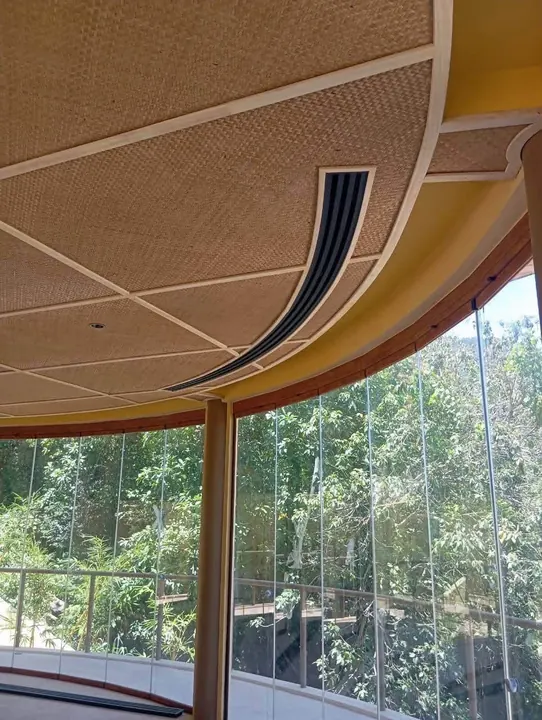 Curved linear slot diffusers in a woven timber ceiling